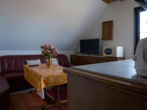een woonkamer met een bank en een vaas met bloemen op een tafel bij Holiday Apartment 2 House Marie in Großenbrode-Kai +9 foto's