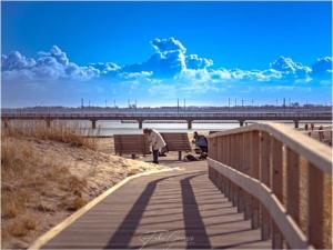 een vrouw die over een promenade langs het strand loopt bij Holiday Apartment 2 House Marie in Großenbrode-Kai