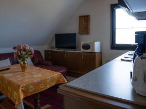 een keuken met een tafel met een vaas met bloemen bij Holiday Apartment 2 House Marie in Großenbrode-Kai