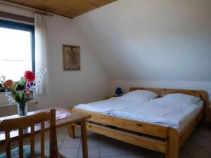 een slaapkamer met een bed, een tafel en een raam bij Holiday Apartment 2 House Marie in Großenbrode-Kai