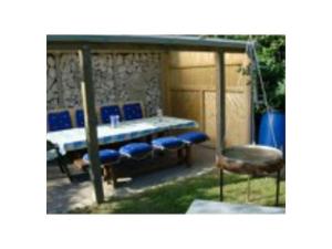 een patio met een tafel en blauwe stoelen bij Holiday Apartment 2 House Marie in Großenbrode-Kai