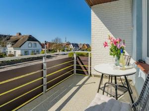 a table on a balcony with a vase of flowers at One-bedroom apartment in Westerland (Sylt)