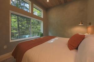a bedroom with a bed and a large window at Cozy Luxury Cabin w Hot Tub, Fire Pit, King Bed in Newry