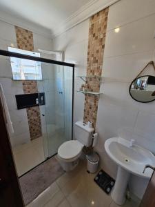 ein Badezimmer mit Dusche, Toilette und Waschbecken in der Unterkunft Aproveite suas férias em família in Balneário Camboriú