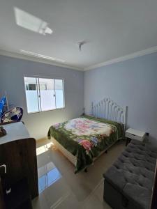 ein Schlafzimmer mit einem Bett und einer Couch und einem Fenster in der Unterkunft Aproveite suas férias em família in Balneário Camboriú