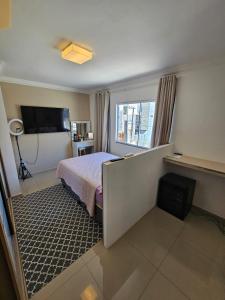 ein Hotelzimmer mit einem Bett und einem Fenster in der Unterkunft Aproveite suas férias em família in Balneário Camboriú