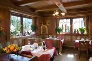 a dining room with two tables and some windows at Hotel Dorfgasthof Schlösslstube in Stuhlfelden