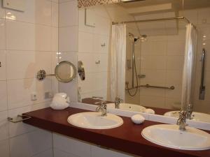 a bathroom with two sinks and a large mirror at Holiday apartment in Baabe with swimming pool in Baabe +16 photos