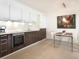 a kitchen with white cabinets and a table with chairs at One-bedroom apartment in Sassnitz +13 photos