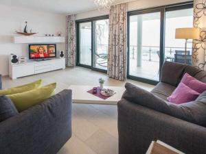 a living room with two couches and a tv at One-bedroom apartment in Sassnitz