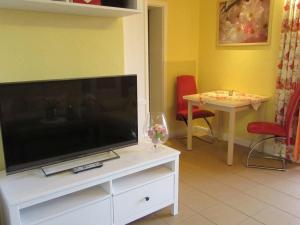ein Wohnzimmer mit Flachbildfernseher und Tisch in der Unterkunft One-bedroom apartment in Otterndorf
