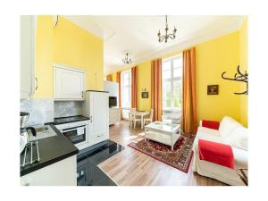 a kitchen and a living room with yellow walls at Groß Helle Manor House in Wrodow