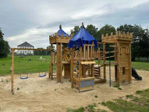 a playground in a park with a wooden play structure at Groß Helle Manor House in Wrodow