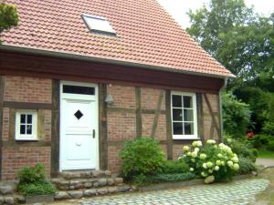 LosentitzにあるHoliday apartment with 2 bedroomsの白い扉のある小さなレンガ造りの家