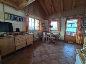 a living room with a table and a television at Cabin in Wiler with sauna and Wi-Fi in Wiler