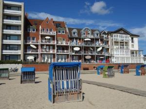 a beach with chairs and a large building at direct sea view Amrum in Wyk auf Föhr