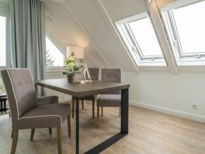 ein Esszimmer mit Tisch und Stühlen und Fenstern in der Unterkunft One-bedroom apartment in Munkmarsch