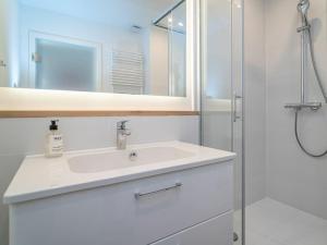 ein weißes Badezimmer mit Waschbecken und Dusche in der Unterkunft One-bedroom apartment in Munkmarsch + 35 Fotos