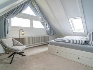 Schlafzimmer im Dachgeschoss mit einem Bett und einem Stuhl in der Unterkunft One-bedroom apartment in Munkmarsch