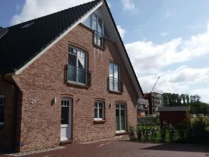 a brick house with windows and a black roof at Holiday home with 4 bedrooms in Wittendün