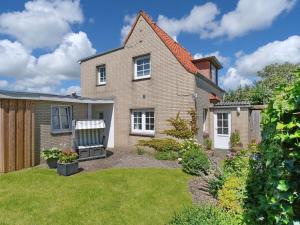 威克奥夫弗尔Holiday apartment in Wyk with swimming pool的院子内有长凳的房子