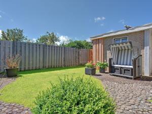 威克奥夫弗尔Holiday apartment in Wyk with swimming pool的后院设有围栏和围栏