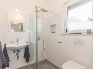 a white bathroom with a shower and a sink at 1-bedroom holiday home in Nova Vas