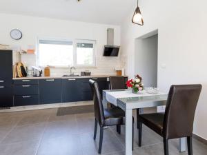 a kitchen with a table and chairs and a sink at 1-bedroom holiday home in Nova Vas +13 photos
