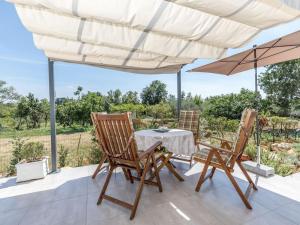 a table and two chairs under an umbrella on a patio at 1-bedroom holiday home in Nova Vas