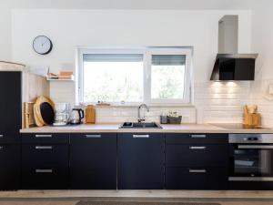 a kitchen with black cabinets and a sink at 1-bedroom holiday home in Nova Vas