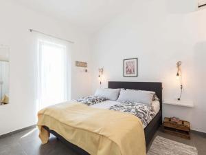 a bed in a white room with a large window at 1-bedroom holiday home in Nova Vas