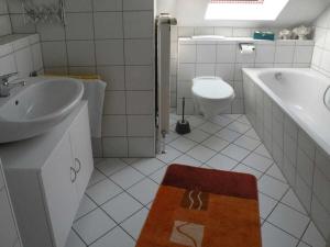 a bathroom with a sink and a tub and a toilet at Holiday home in Rügen with 3 bedrooms in Losentitz +15 photos