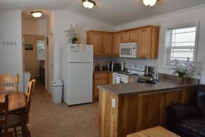 a kitchen with a white refrigerator and wooden cabinets at Cozy Home by Yellowstone River Confluence in Gardiner