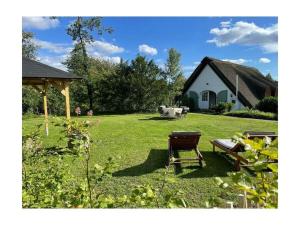 een tuin met een bank, een prieel en een huis bij 1-bedroom cottage in Hornsmühlen
