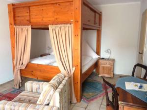 ボルクムにあるOne-bedroom apartmentの二段ベッドとソファのある寝室