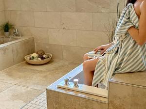 a woman sitting in a bath tub in a bathroom at Wellness Residence Apartment 19 in Zingst +33 photos