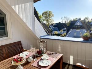a table with plates and glasses on a balcony at Wellness Residence Apartment 19 in Zingst