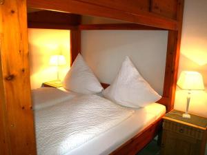 a bedroom with a bed with white sheets and pillows at One-bedroom apartment in Borkum