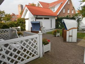 two chairs and a fence in front of a house at One-bedroom apartment in Borkum
