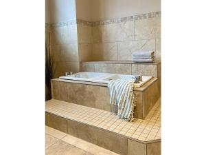 a bathroom with a tub and a tiled floor at Wellness Residence Apartment 12 in Zingst +33 photos