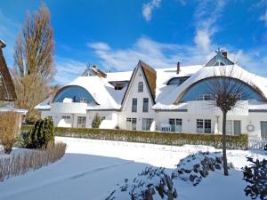 a white house with snow on the ground at Wellness Residence Apartment 12 in Zingst