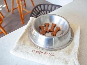 una ciotola di metallo piena di biscotti per cani su un tavolo di The Woodshed a Sheepwash