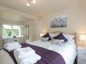 a bedroom with a bed with towels on it at The Coach House in Wootton Bridge