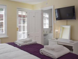 a bedroom with a bed with a vanity and a mirror at The Coach House in Wootton Bridge