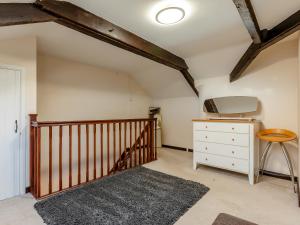 Cette chambre mansardée dispose d'un escalier et d'une commode. dans l'établissement Orchard Cottage - Uk30437, à Kingsbury Episcopi 3 autres photos