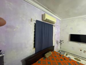 a small bedroom with a bed and a window at Les bois sacrés house in Cococodji