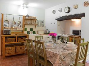 ein Esszimmer mit Tisch und Stühlen und eine Küche in der Unterkunft Wood Cottage in Cheriton