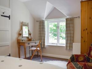 Schlafzimmer mit einem Schreibtisch und einem Fenster in der Unterkunft Wood Cottage in Cheriton
