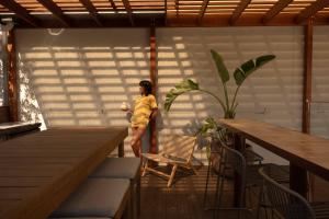 a woman in a yellow dress standing on a deck at Drifter Byron Bay in Byron Bay