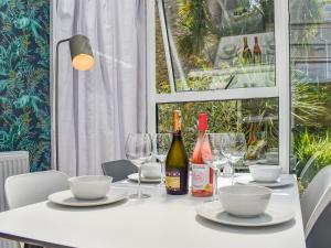 a white table with glasses and bottles of wine at Garden Flat in Ryde